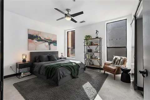 a bedroom with a bed a couch and a chandelier