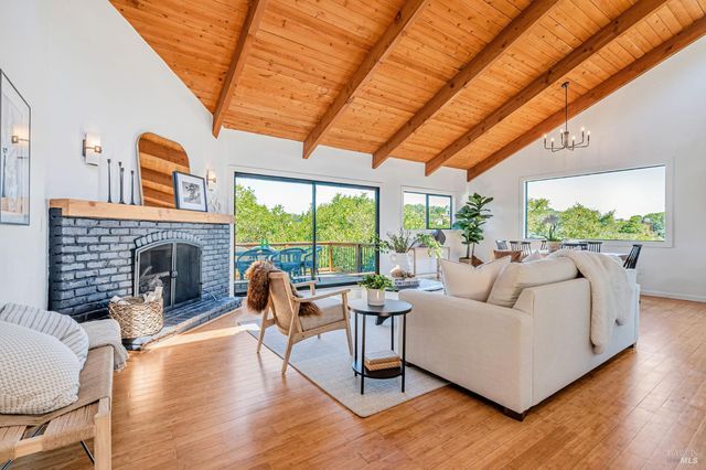 a living room with furniture a fireplace and a large window