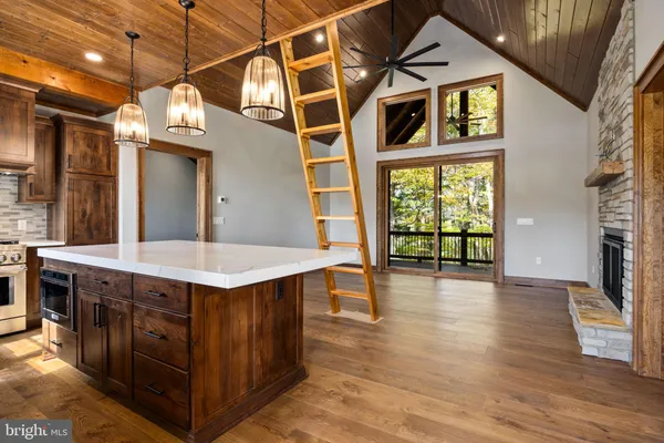 a kitchen with a stove and wooden floor