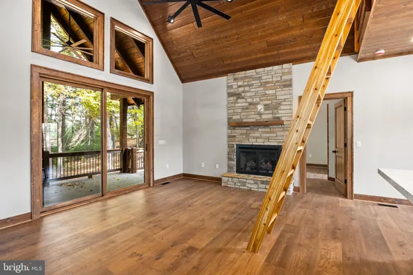 a view of an empty room with a fireplace and a window