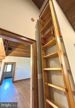 a view of a hallway with wooden floor and staircase