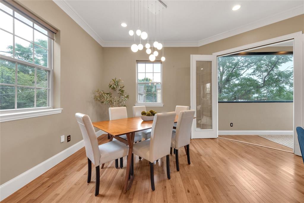5102 Ridgedale Avenue Dallas, TX 75206 - Photo 6 of 27 Dining area featuring hardwood flooring, crown molding, a contemporary chandelier, multiple windows, and glass-paneled French doors