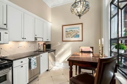 252 Commonwealth Avenue, Unit 4 Boston, MA 02116 - Photo 6 of 14 a kitchen with stainless steel appliances granite countertop a stove a sink dishwasher and white cabinets with wooden floor