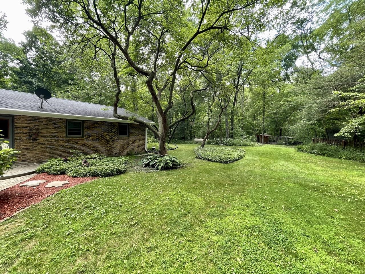 6840 Best Road Pecatonica, IL 61063 - Photo 3 of 29 a view of backyard with table and chairs and large trees