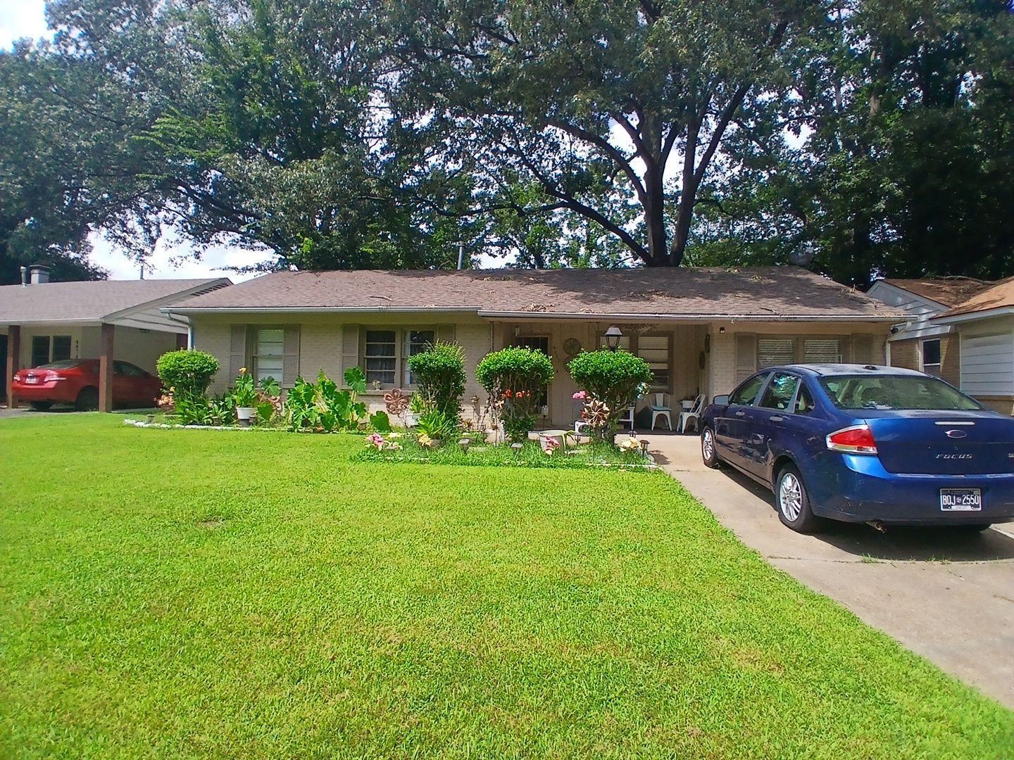 4480 Garnett Road Memphis, TN 38117 - Photo 1 of 15 Expansive front lawn, concrete driveway, front porch, mature trees, and established landscaping