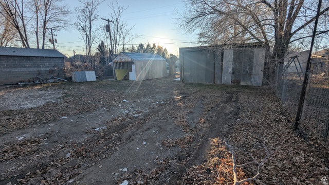 436 Rose Avenue Price, UT 84501 - Photo 24 of 36 Expansive rear yard area featuring two storage sheds, a chain-link fence, and mature trees