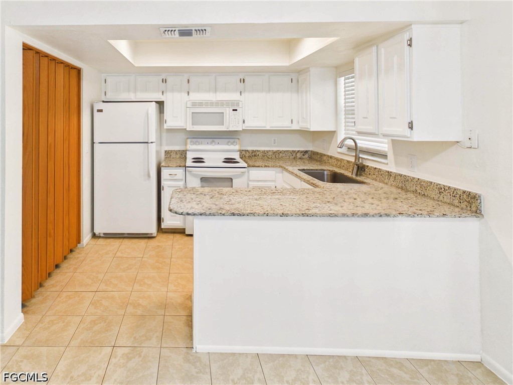 18541 Iris Road Fort Myers, FL 33967 - Photo 6 of 18 a kitchen with stainless steel appliances granite countertop a refrigerator sink and white cabinets