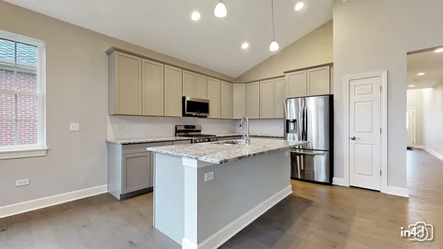 a kitchen with a refrigerator a stove top oven a sink and cabinets