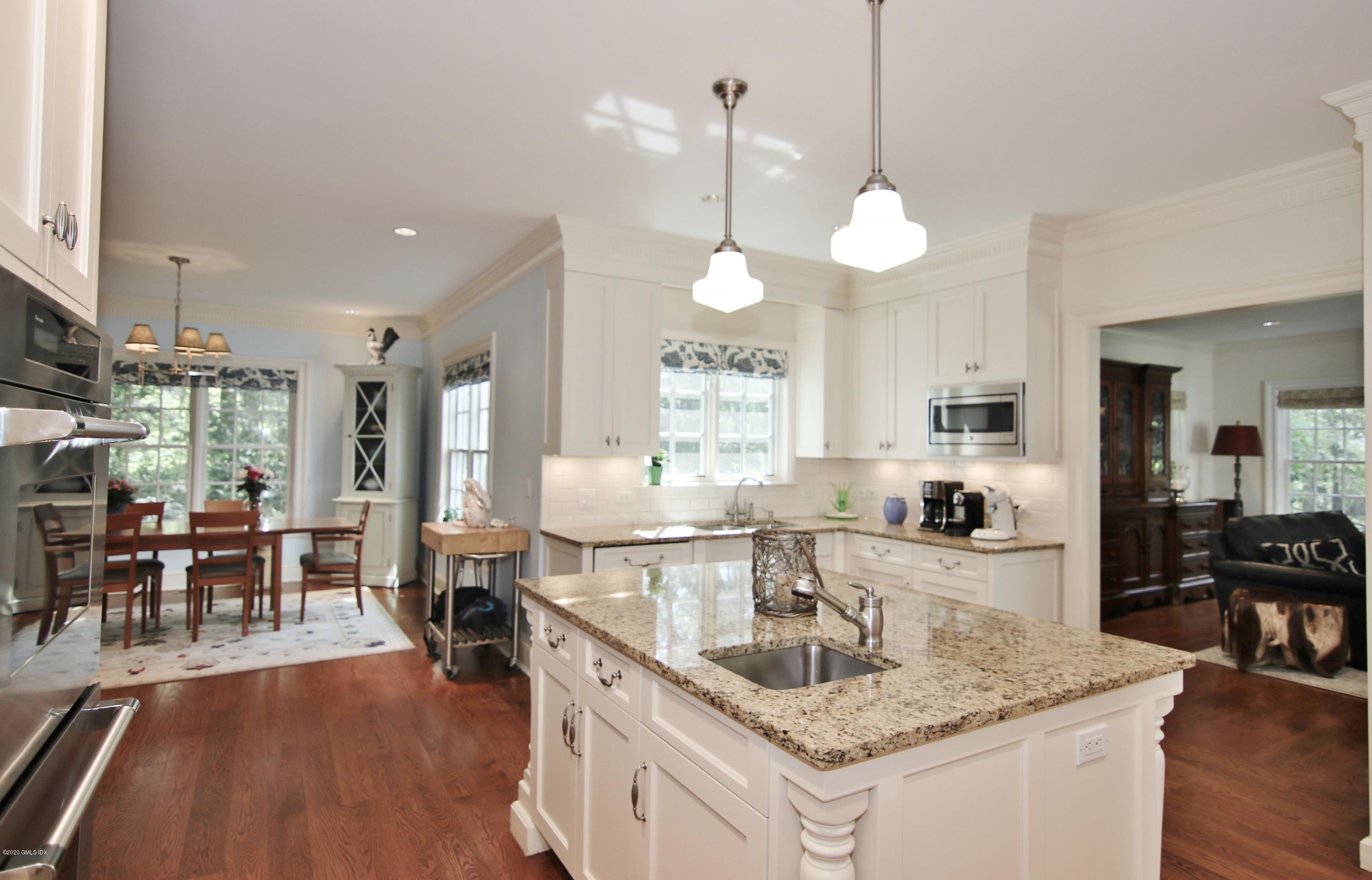 8 Hockanum Road Westport, CT 06880 - Photo 7 of 41 a kitchen with granite countertop a dining table chairs stove and white cabinets