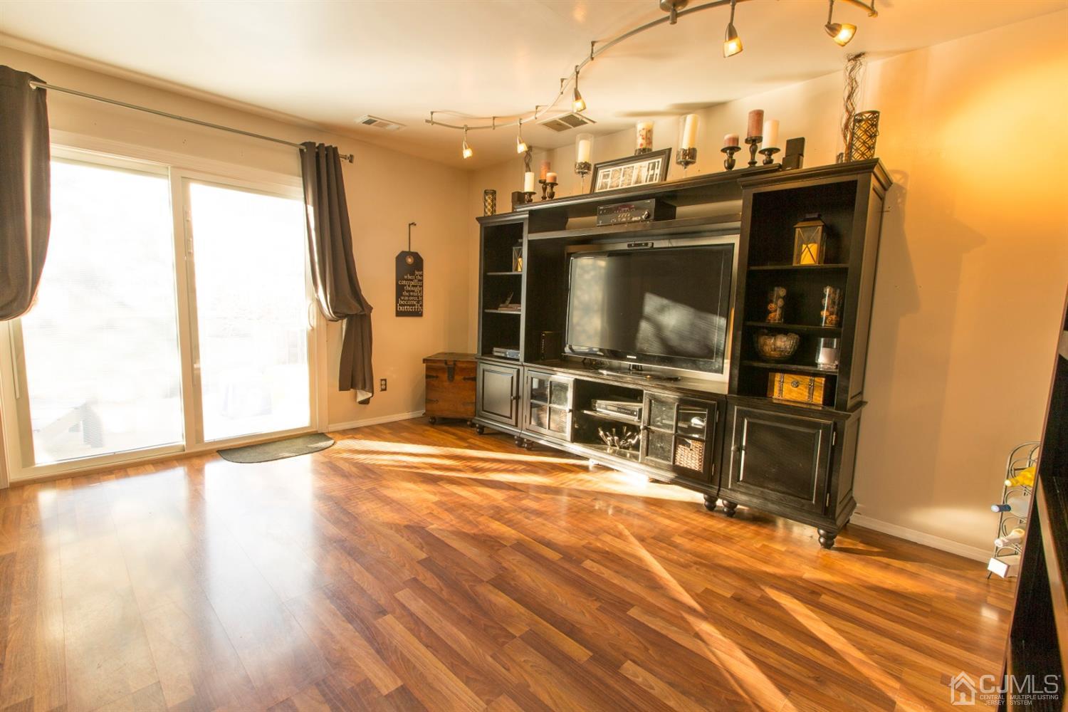 59 La Rue Lane East Brunswick, NJ 08816 - Photo 4 of 18 a living room with a flat screen tv and a floor to ceiling window