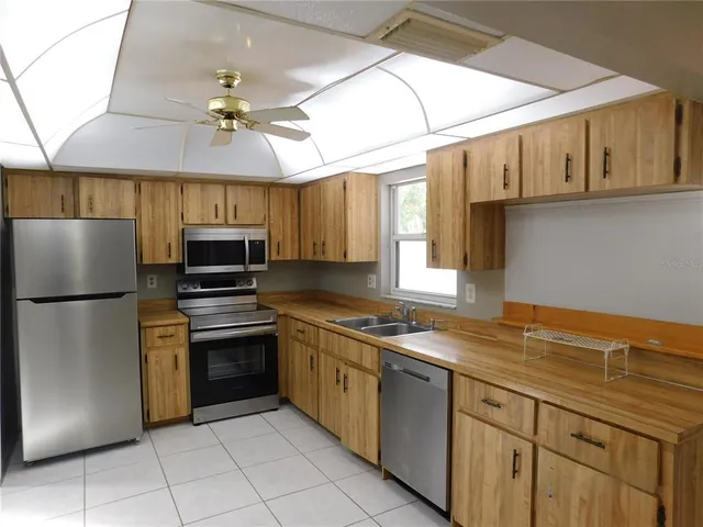 a kitchen with stainless steel appliances granite countertop a stove a sink and a refrigerator