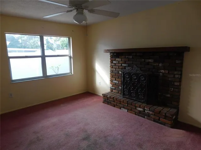 an empty room with a fireplace and window