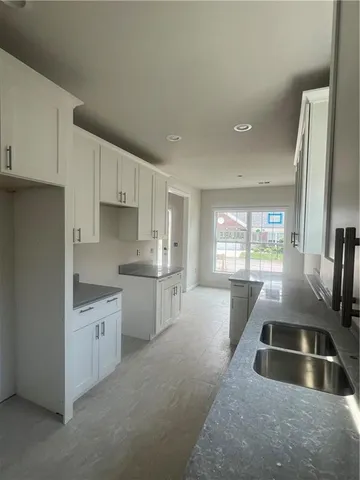 a kitchen with granite countertop a sink stainless steel appliances and cabinets