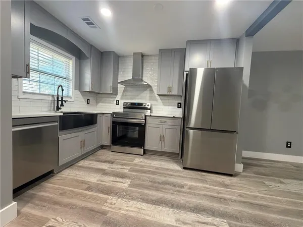 a kitchen with stainless steel appliances a refrigerator sink and cabinets