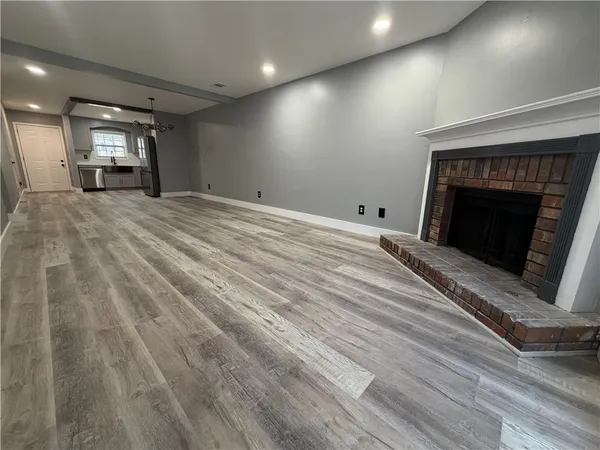 an empty room with wooden floor and fireplace