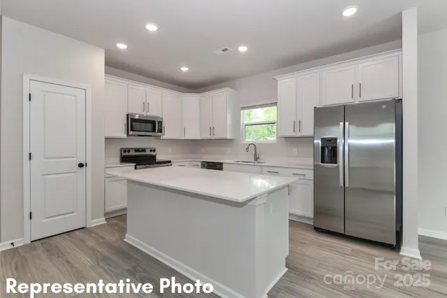 a kitchen with kitchen island a counter top space cabinets and stainless steel appliances