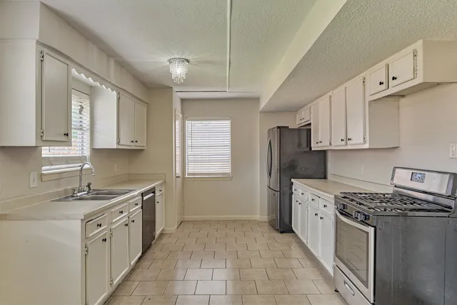 a kitchen with a sink stove and cabinets