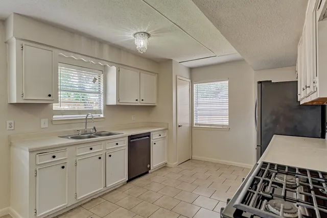 a kitchen with a sink stove and cabinets