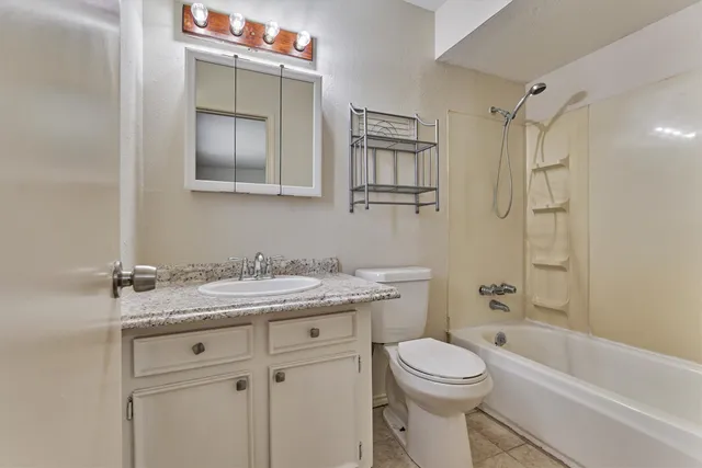 a bathroom with a granite countertop sink toilet and shower