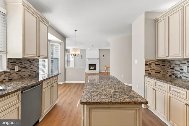 an empty room with wooden floor a fireplace and windows