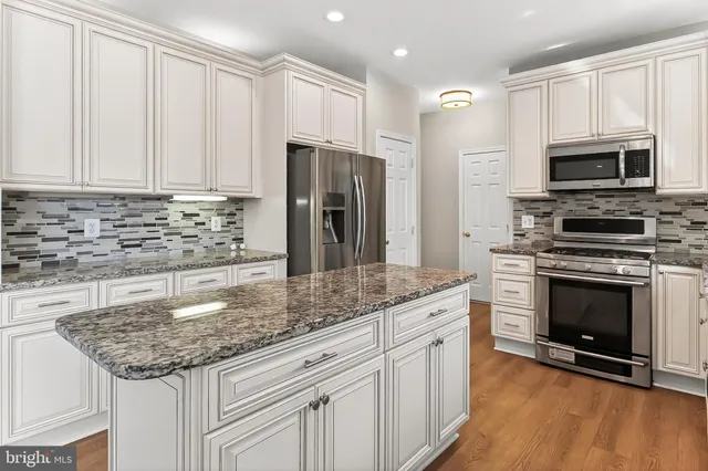 a view of a living room a kitchen with wooden floor