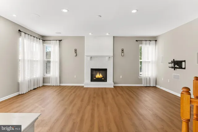 a view of a hallway with wooden floor and stairs