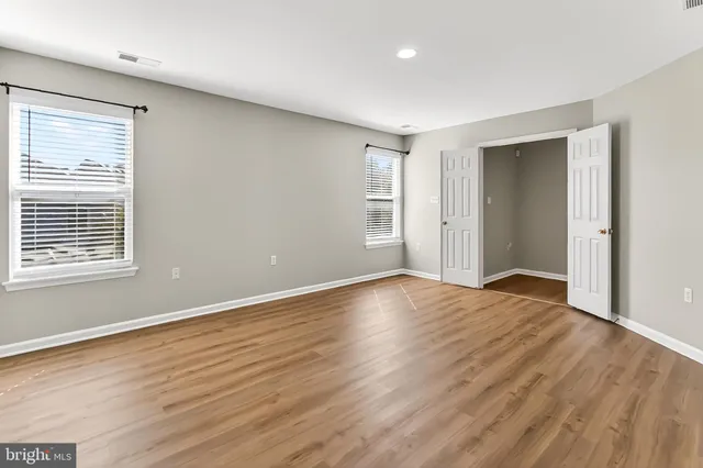 a view of a hallway with wooden floor and entryway