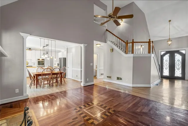 a view of a livingroom with furniture a ceiling fan and wooden floor