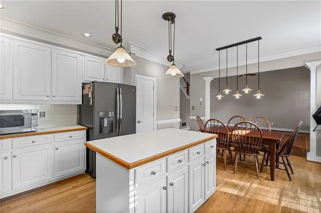 a kitchen with stainless steel appliances a kitchen island a stove a table and chairs in it