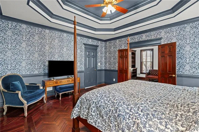 a bedroom with a bed a chair and a flat screen tv