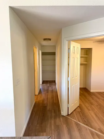 a view of a hallway with wooden floor