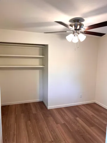 a view of an empty room with a chandelier fan