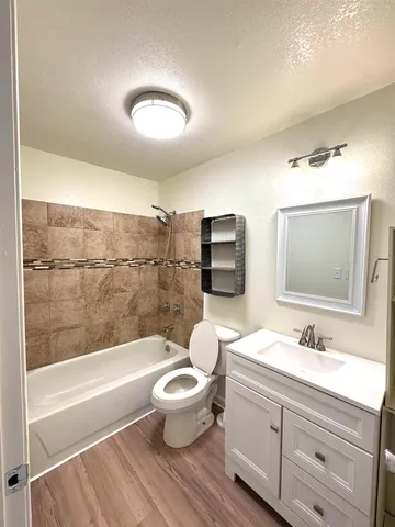 a bathroom with a bathtub shower sink mirror and toilet