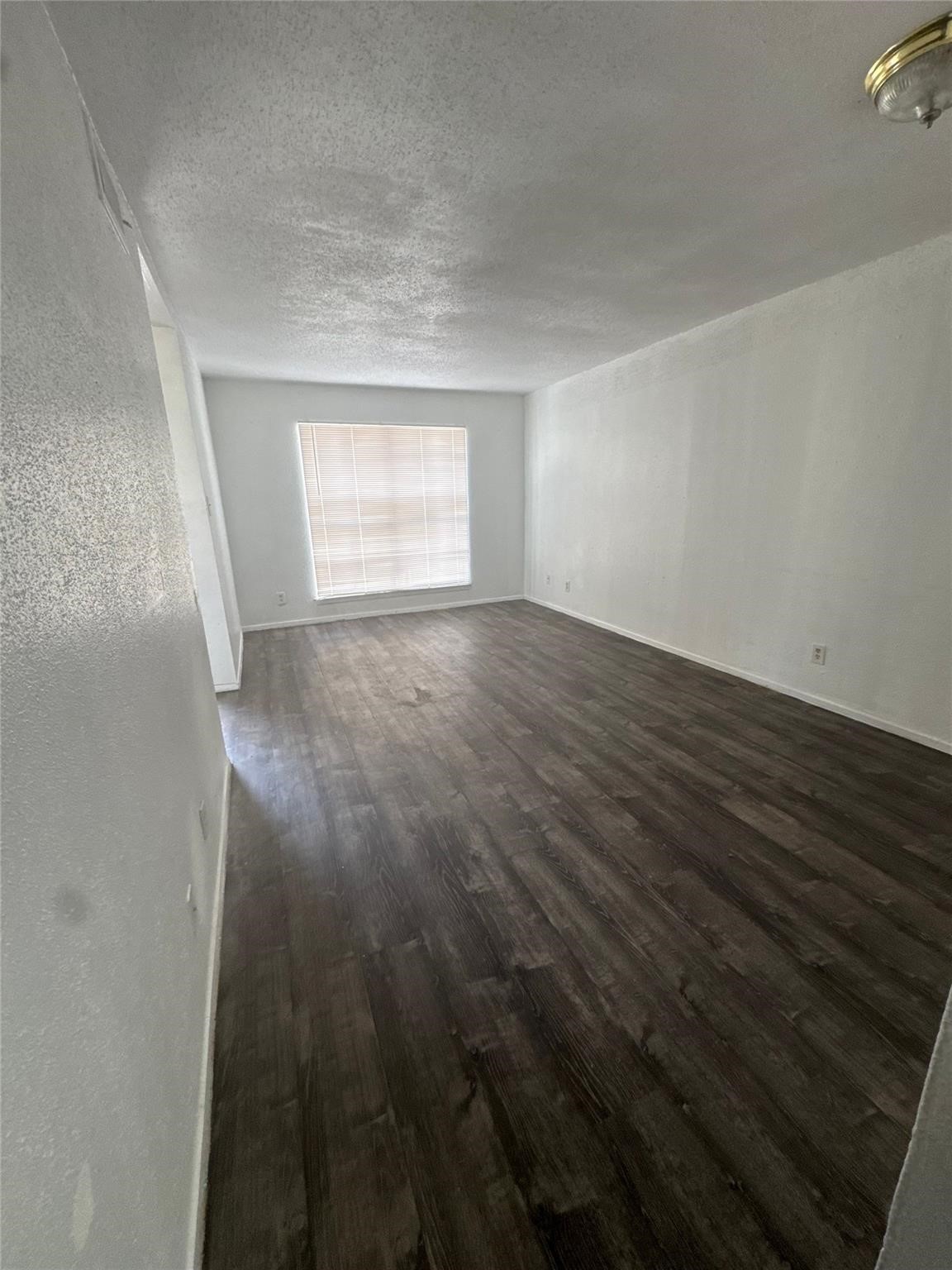 6200 West Tidwell Road, Unit 1205 Houston, TX 77092 - Photo 4 of 14 an empty room with wooden floor and windows