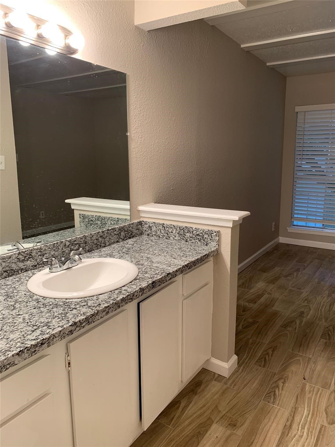 6200 West Tidwell Road, Unit 1205 Houston, TX 77092 - Photo 6 of 14 a bathroom with a granite countertop sink and a mirror