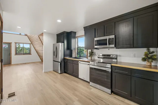 a view of a patio with couches and table and chairs with wooden floor and fence