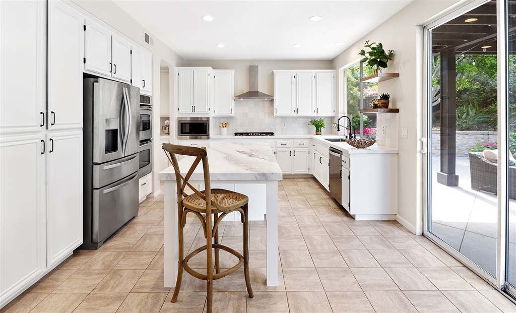 3445 Camino Alegre Carlsbad, CA 92009 - Photo 6 of 25 a kitchen with stainless steel appliances a refrigerator sink and cabinets