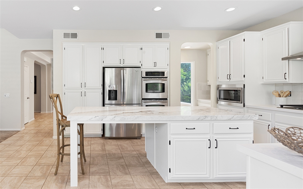 3445 Camino Alegre Carlsbad, CA 92009 - Photo 8 of 25 a kitchen with stainless steel appliances a white stove top oven and cabinets