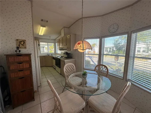 a view of a dining room with furniture wooden floor kitchen and chandelier