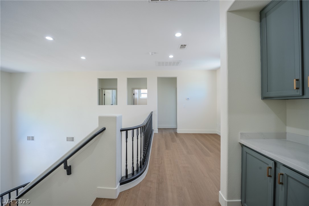 1832 Spring Summit Lane Las Vegas, NV 89134 - Photo 22 of 52 Recessed lighting illuminates a gracefully curved staircase and sleek wooden floors on this upper landing.