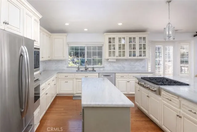 a kitchen with granite countertop a sink stainless steel appliances and window