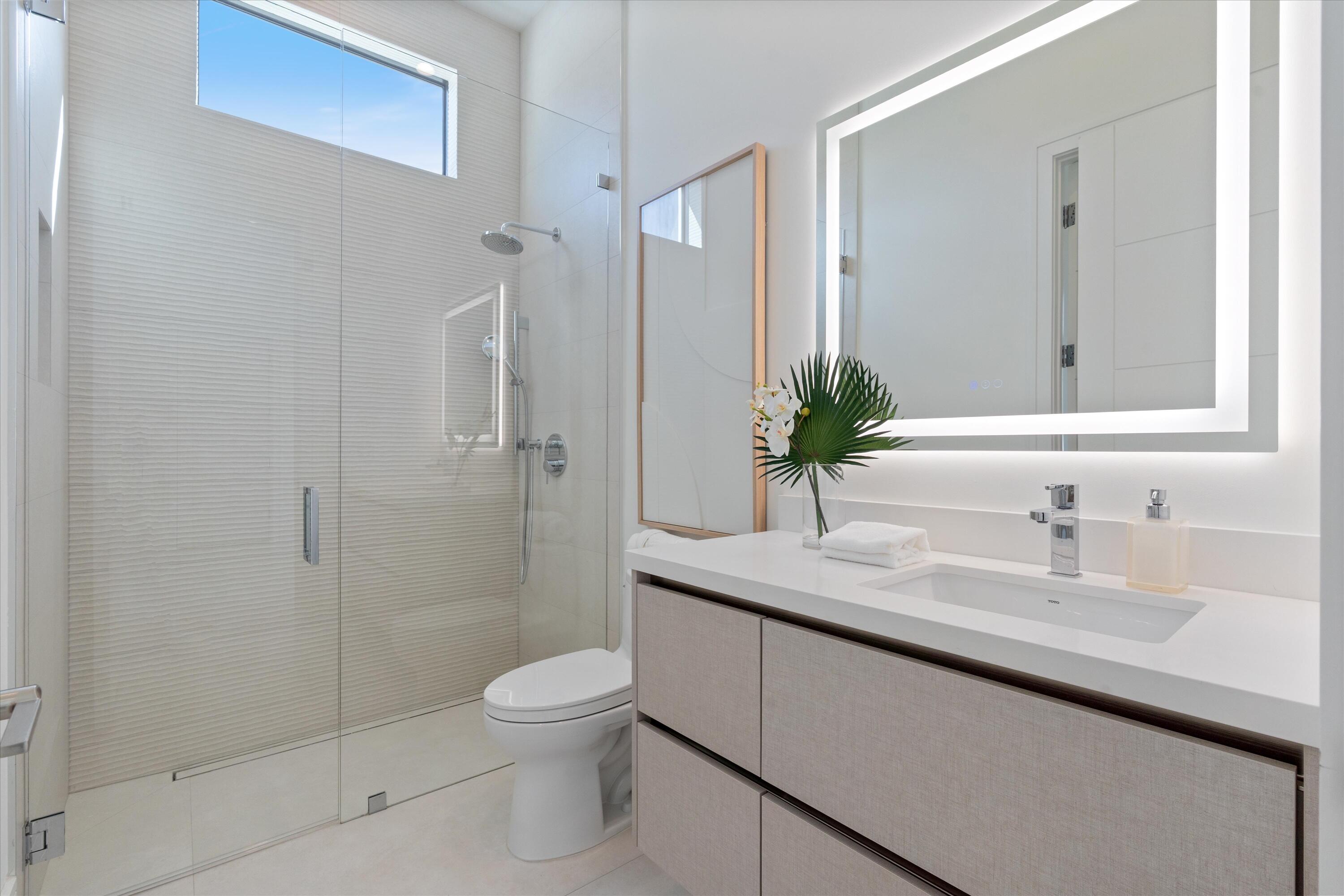 498 Northeast 6th Street Boca Raton, FL 33432 - Photo 15 of 60 a bathroom with a granite countertop sink a toilet and shower