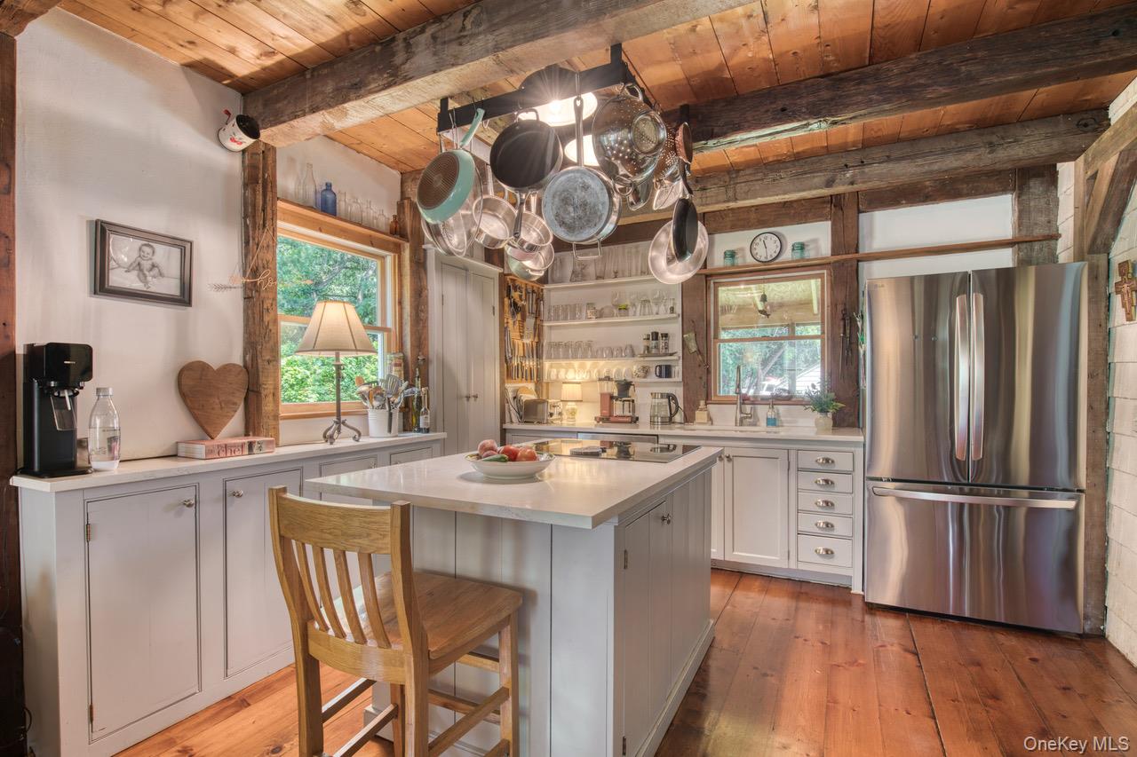7635 Main Bayview Road Southold, NY 11971 - Photo 13 of 20 a kitchen with stainless steel appliances granite countertop a stove a refrigerator a sink dishwasher and white cabinets with wooden floor