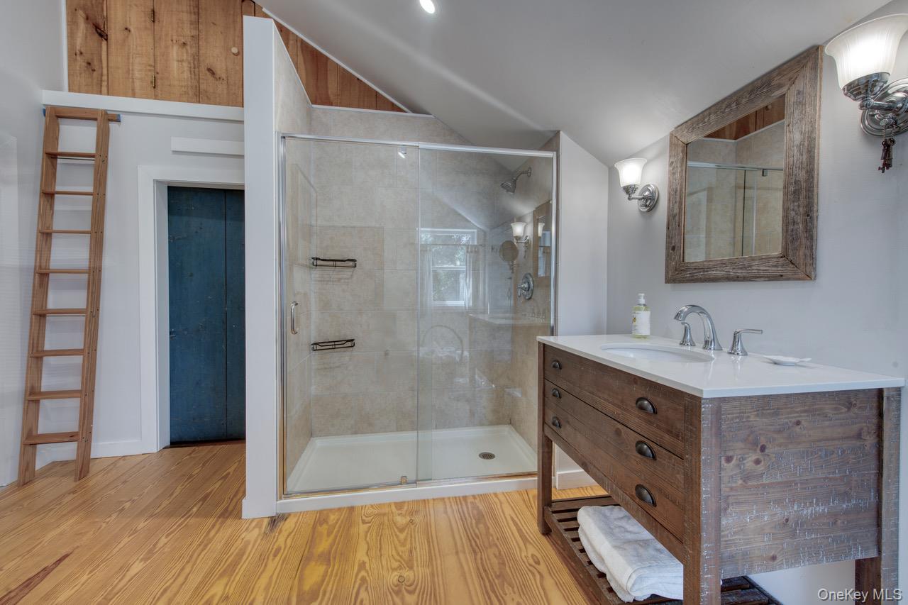 7635 Main Bayview Road Southold, NY 11971 - Photo 20 of 20 a bathroom with a shower sink and mirror