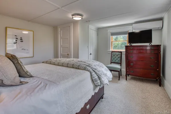 a bedroom with a bed and painting on the wall