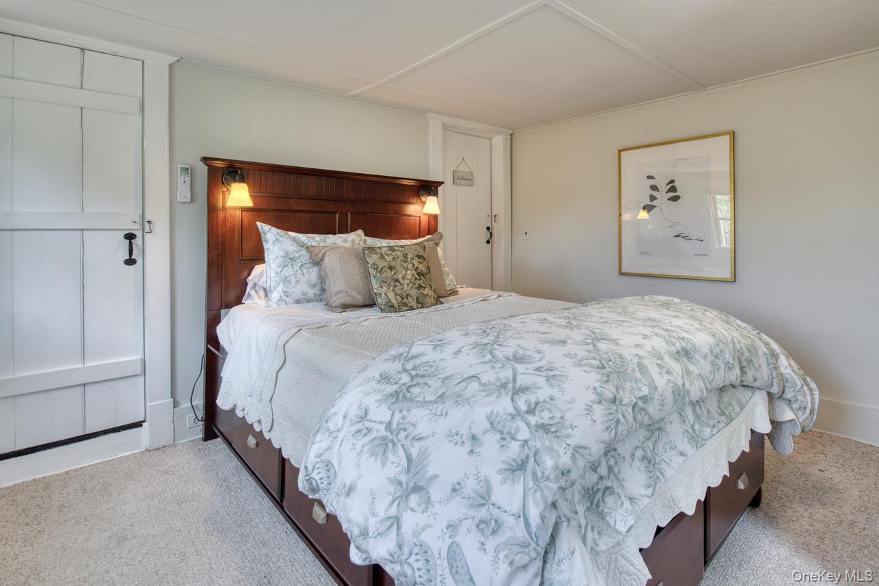 7635 Main Bayview Road Southold, NY 11971 - Photo 6 of 20 a bedroom with a bed and painting on the wall