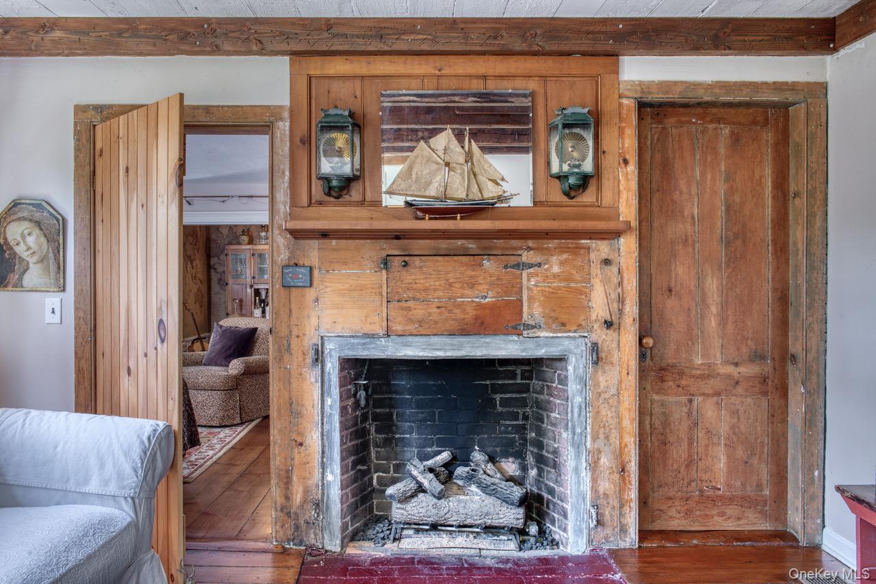 7635 Main Bayview Road Southold, NY 11971 - Photo 7 of 20 a living room with a fireplace and a wooden floor
