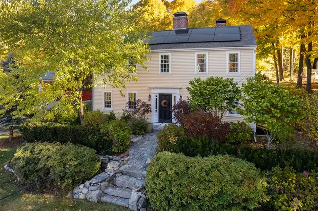 a white house that has a lot of plants in it