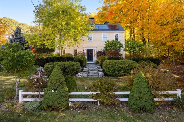 a view of a house with a yard and large trees