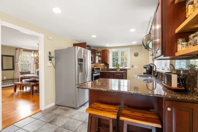 a kitchen with stainless steel appliances granite countertop a stove a refrigerator and a microwave
